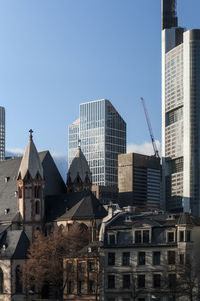 Buildings in city against clear blue sky