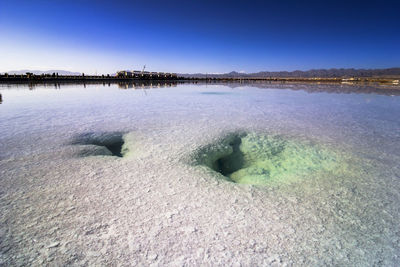 Scenic view of river against clear blue sky during winter