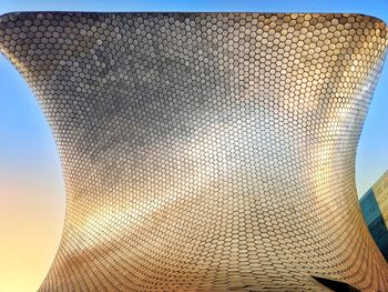 Low angle view of metal structure against sky during sunset