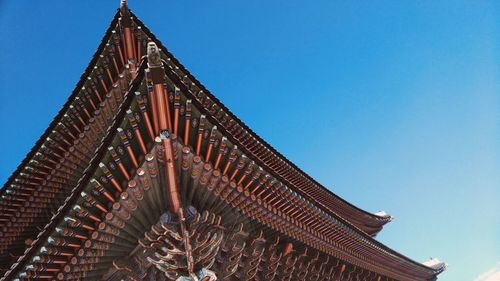 Low angle view of gyeongbokgung palace roof against clear blue sky