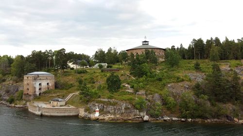 View of building by river against sky