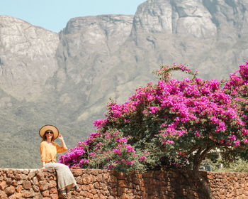 Rear view of woman sitting on rock