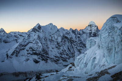 Scenic view of snowcapped mountains against clear sky during winter