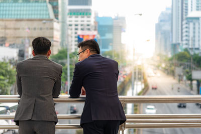 Rear view of people walking in city buildings