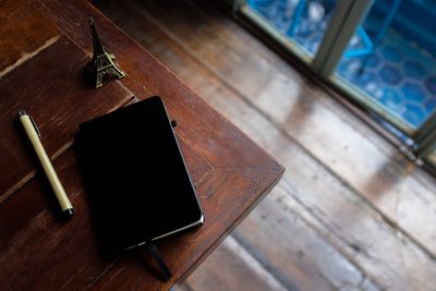 High angle view of book and pen on table