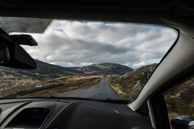 Scenic view of mountains seen through car windshield