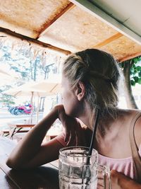 Portrait of woman drinking glass on table