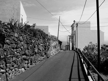 View of railroad tracks by road against sky