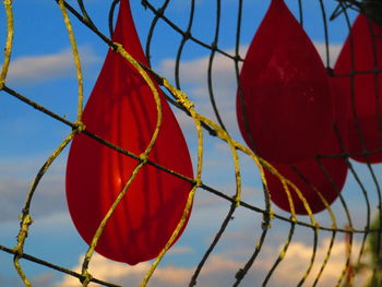 Low angle view of red decoration hanging against sky