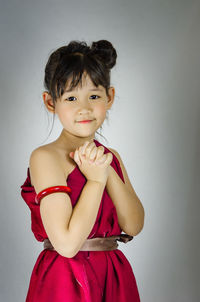Portrait of beautiful young woman against gray background