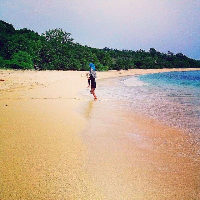 beach, water, full length, sand, sea, lifestyles, leisure activity, shore, rear view, tranquil scene, tranquility, standing, clear sky, casual clothing, scenics, sky, beauty in nature, vacations