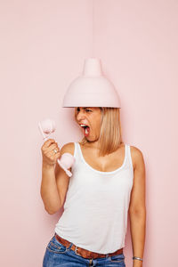 Midsection of woman holding umbrella against wall