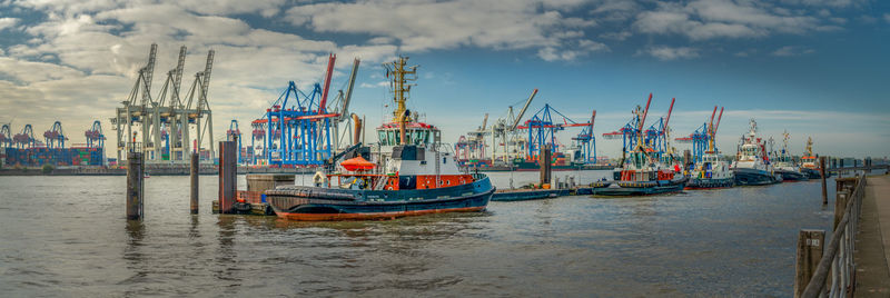 Fishing boats moored at harbor against sky in hamburg