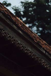 Low angle view of cross on roof against sky