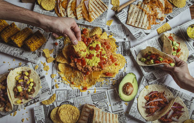 Friends dining on the mexican taco. shot of beef tacos, tomato sauce, tortillas, nachos 