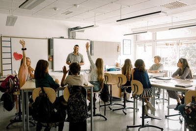 Male and female students with teacher in classroom