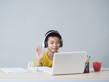 Portrait of man using mobile phone while sitting on table