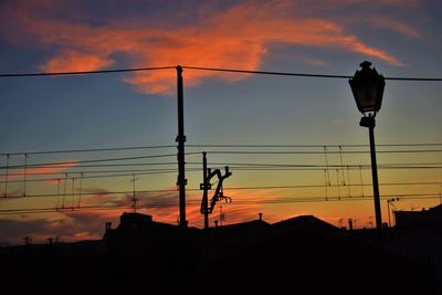 Low angle view of street light against dramatic sky