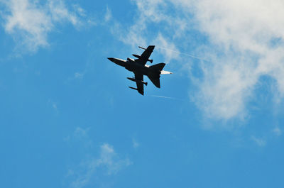 Low angle view of airplane flying against blue sky