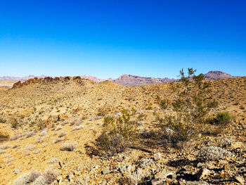 Scenic view of desert against clear blue sky