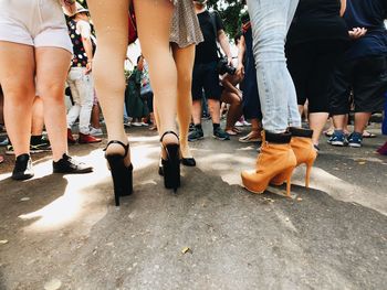 Low section of people walking on street in city