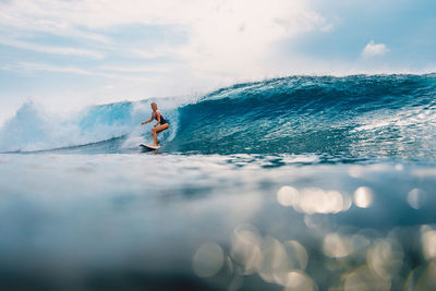 Man surfing in sea against sky