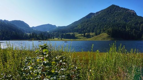 Scenic view of lake by mountains against sky