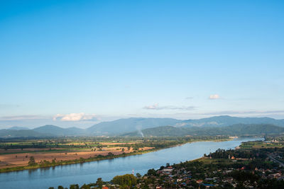 Scenic view of river and mountains against blue sky