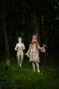 Full length of a girl standing against trees