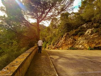 Rear view of man jogging on footpath