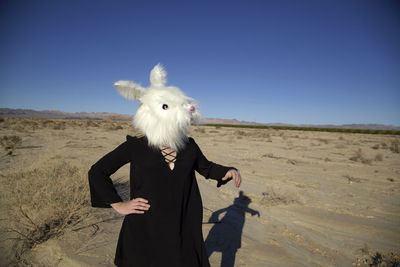 Woman standing against blue sky