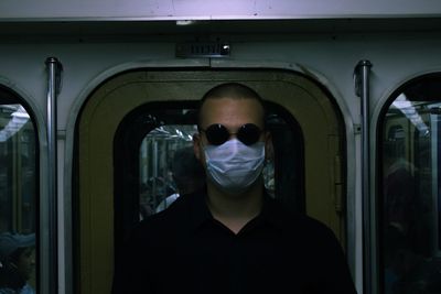 Portrait of man wearing sunglasses in train