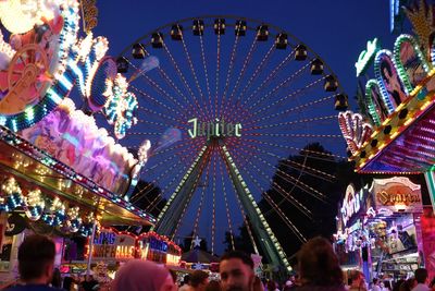 People in amusement park against sky in city