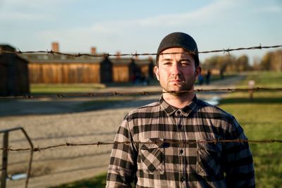 Portrait of young man standing against sky