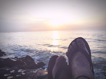 Low section of man relaxing on beach