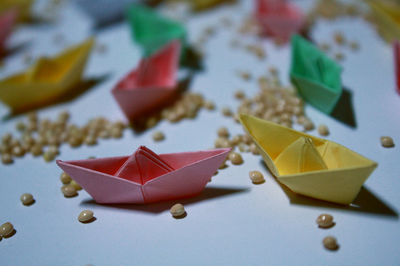 High angle view of colorful paper boats with beans on table