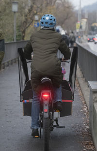 Rear view of man riding motorcycle on road