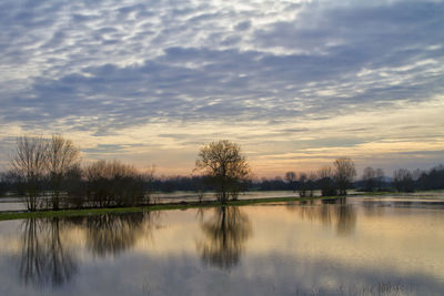 Scenic view of lake against sky at sunset