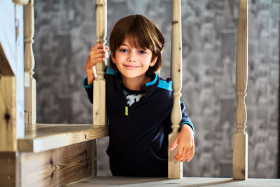 Portrait of boy sitting on railing