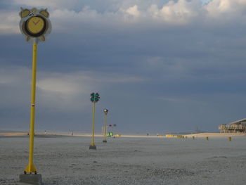 Street light by sea against sky