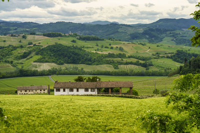 Scenic view of agricultural field by mountains against sky