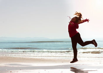 Full length of woman at beach against sky