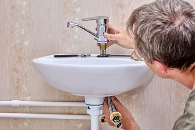 Side view of woman washing hands in bathroom