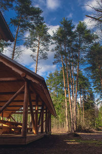 Low angle view of bridge in forest against sky
