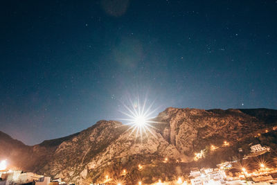 Low angle view of illuminated mountain against sky at night