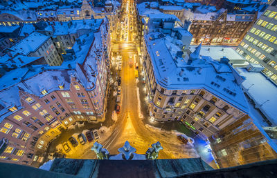 High angle view of buildings and street in city lit up at night