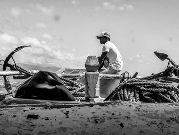 Rear view of people working on land against sky