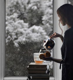 Woman standing by glass window