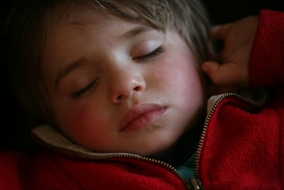 Close-up of cute baby boy sleeping on bed