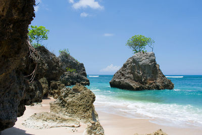 Rock formation on beach against sky